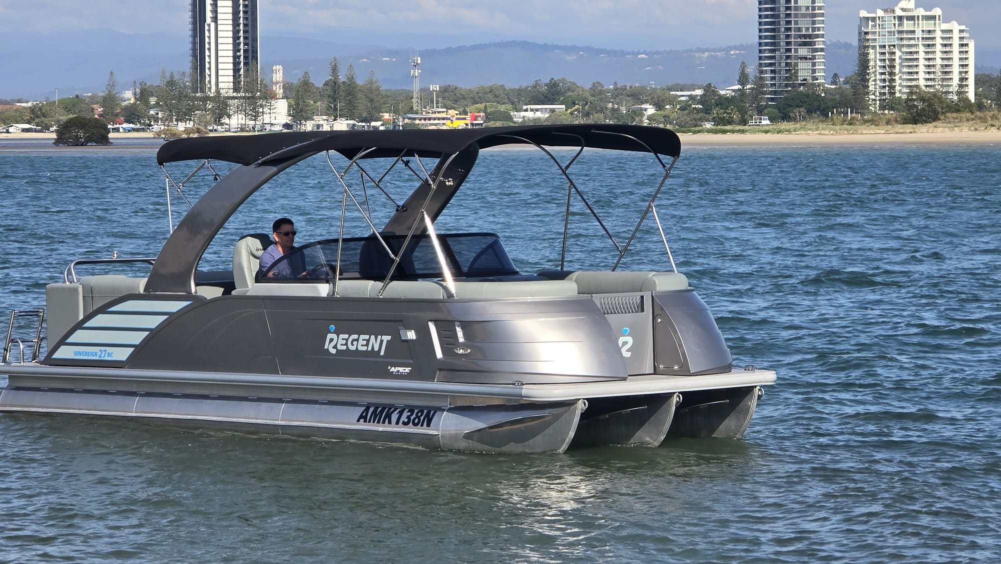 A tritoon pontoon boat out on the water